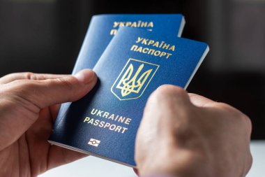 Elinde kimlik çipi olan yeni Ukrayna mavi biyometrik pasaportu.