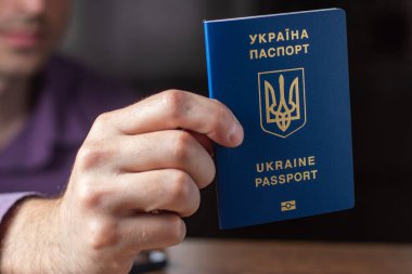 Elinde kimlik çipi olan yeni Ukrayna mavi biyometrik pasaportu.