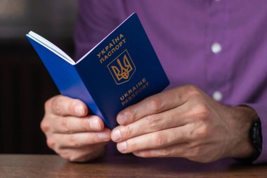 Elinde kimlik çipi olan yeni Ukrayna mavi biyometrik pasaportu.