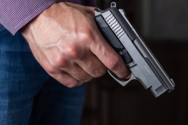 Silah kontrolü kavramı. Silahlı adam tabancayı elinde tutuyor..