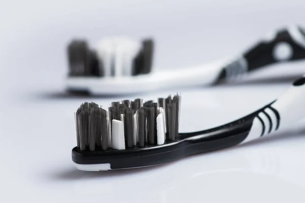 Two Toothbrushes Black White Color Dental Care Lies Table White — Stock Photo, Image