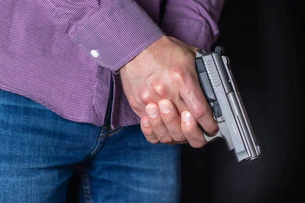 Gun control concept. Armed man holds pistol in hand.