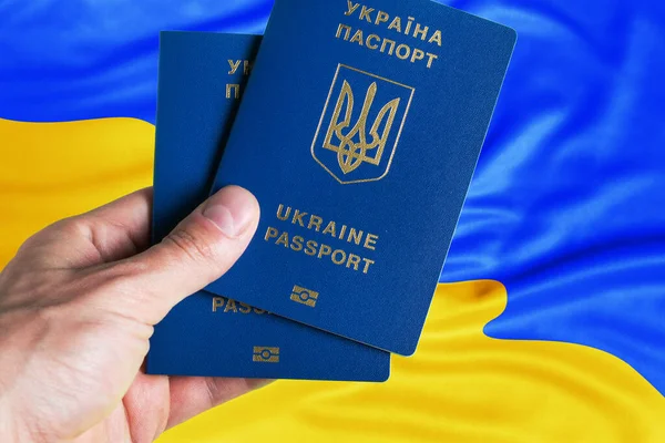 Paszporty Ukrainy Ręku Tle Flagi Ukraińskiej — Zdjęcie stockowe
