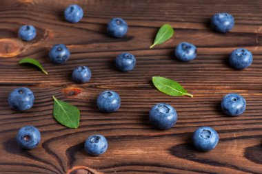 Ahşap arka plan üzerinde yaprakları ile taze yaban mersini.