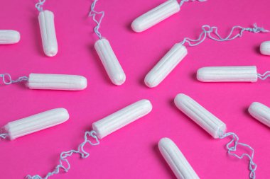 Pembe arka planda tıbbi kadın tamponu. Kadınlar için hijyenik beyaz tampon. Pamuklu çubuk. Regl, korunma aracı. Kırmızı arkaplanda tamponlar.