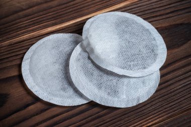 Tea bags on wooden background, close up.