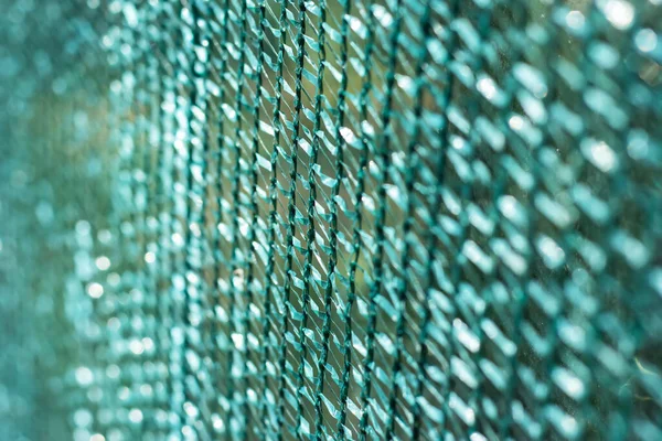 Knitted polyethylene mesh background, sun protection material that creates shade danger of solar overheating concept.