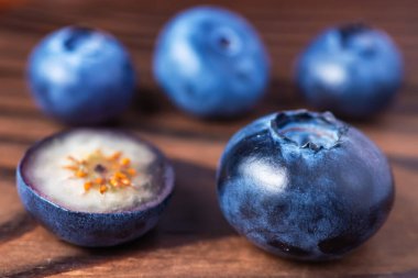 fresh Blueberries with cut in half on wooden background