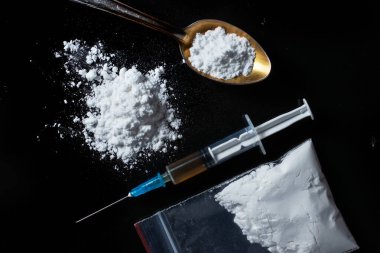 Konsept uyuşturucu bağımlılığı. Uyuşturucu ve Yasadışı Uyuşturucu Kaçakçılığına Karşı Uluslararası Gün. Siyah arka planda uyuşturucu