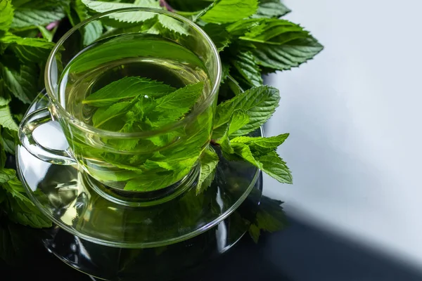 Mint Tea. Herbal tea. Mint leaf. Mint leaves. Tea in a glass cup. herbs tea and mint leaves on a slate plate.