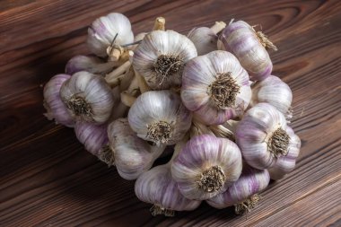 Ahşap arka planda izole edilmiş sarımsak demeti..