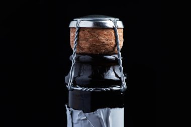 Siyah arka planda şişe mantarlı şampanya..