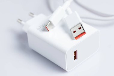 Beyaz arka planda USB kablosu olan beyaz şarj aleti