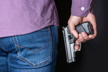 Arka kapağı transparan, yakın çekim görüşünü arkasında elinde bir silah tutan bir adam. Kavramlar: suç, cinayete teşebbüs, kurşun yarası, katil, soygun