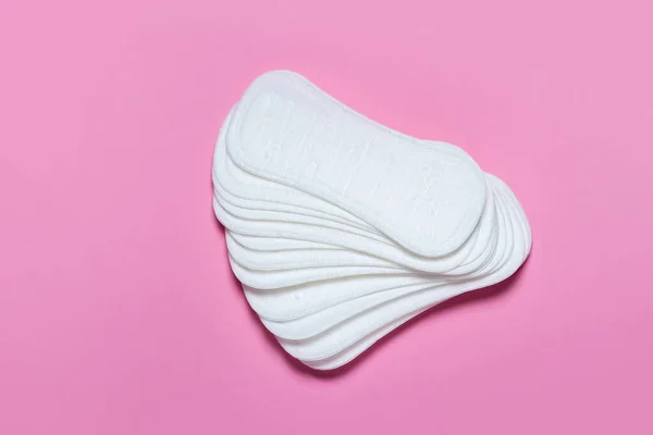 Feminine hygiene pads on a pink background. Concept of feminine hygiene during menstruation. top view