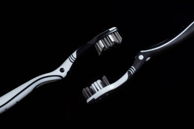 Siyah arkaplanda siyah beyaz diş fırçası.