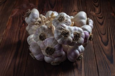 Ahşap arka planda izole edilmiş sarımsak demeti..