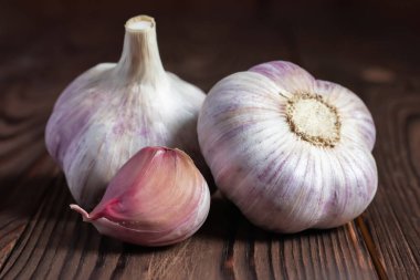 Tahta masada sarımsaklı karanfil. Taze sarımsak ve soğanlar.