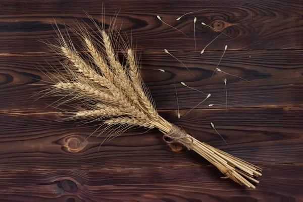 Bouquet Wheat Ears on the Wooden Table. Sheaf of Wheat over Wood Background. Harvest concept.