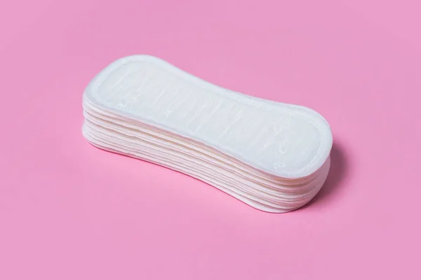 Feminine hygiene pads on a pink background. Concept of feminine hygiene during menstruation