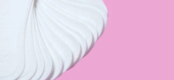 Feminine hygiene pads on a pink background. Concept of feminine hygiene during menstruation. top view