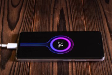 Ahşap masanın üzerinde şarj mobil akıllı telefonlar.