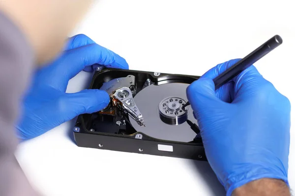 Repair Hard disk. Hands of master in gloves with screwdriver repair the computer hard drive. Data cleaning, HDD recovery