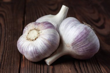 Tahta masada sarımsaklı karanfil. Taze sarımsak ve soğanlar.