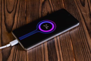 Ahşap masanın üzerinde şarj mobil akıllı telefonlar.