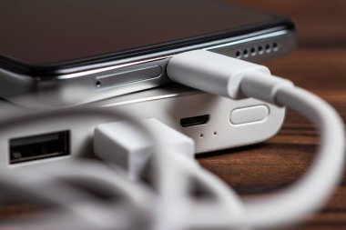 Akıllı telefon beyaz güç bankasıyla şarj ediliyor. Beyaz güç bankasına yakın çekim