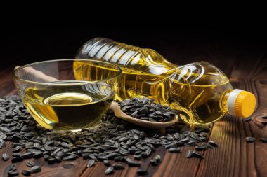 Cam kasede ayçiçeği yağı ve tahta arka planda tahta kaşıkta tohum..