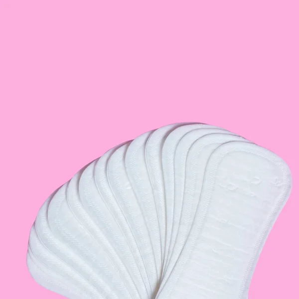 Feminine hygiene pads on a pink background. Concept of feminine hygiene during menstruation. top view