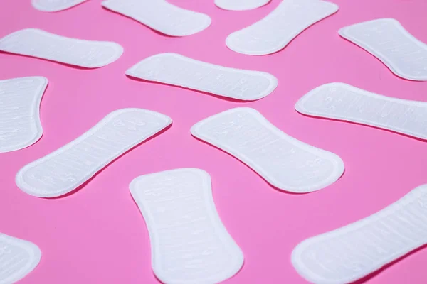 Feminine hygiene pads on a pink background. Concept of feminine hygiene during menstruation. top view