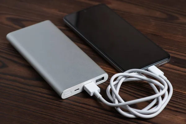 Smartphone charging with white power bank. close-up at white power bank