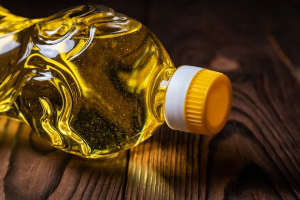 Sunflower oil in bottle on wooden background.