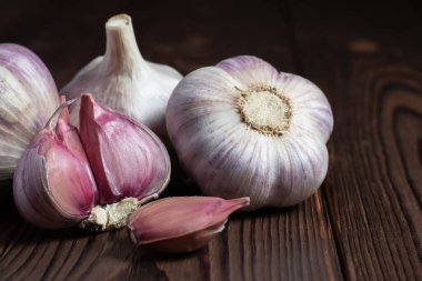 Tahta masada sarımsaklı karanfil. Taze sarımsak ve soğanlar.