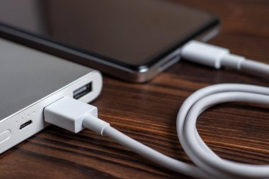 Akıllı telefon beyaz güç bankasıyla şarj ediliyor. Beyaz güç bankasına yakın çekim