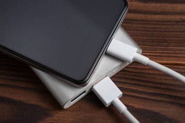 Akıllı telefon beyaz güç bankasıyla şarj ediliyor. Beyaz güç bankasına yakın çekim