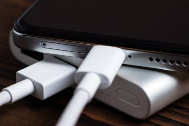 Akıllı telefon beyaz güç bankasıyla şarj ediliyor. Beyaz güç bankasına yakın çekim