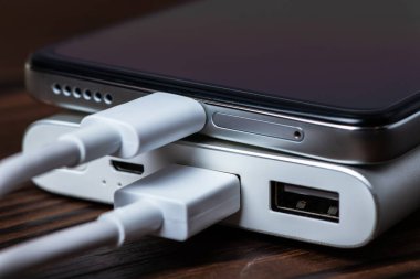 Tahtada elektrik bankasıyla çalışan akıllı telefon..