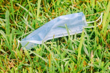 Tek kullanımlık tıbbi maskeler çimlere çöp gibi atılmıştı.