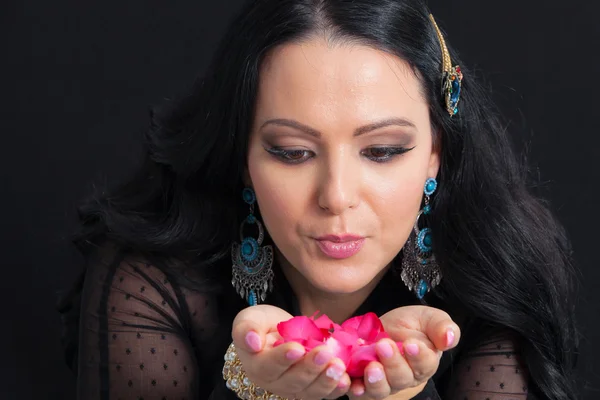 Beautiful woman with rose petals in hands — Stock Photo, Image