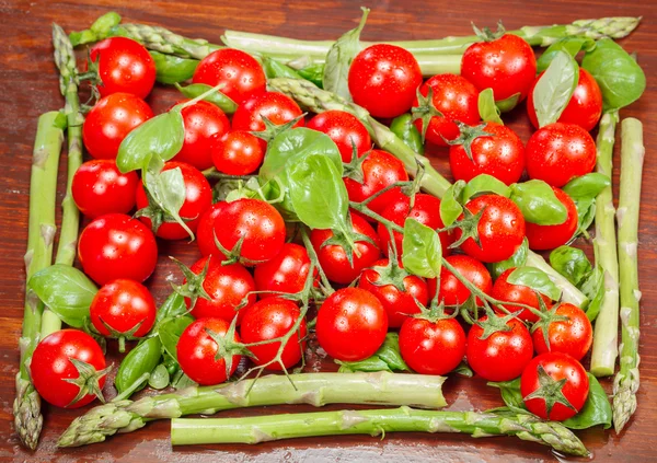 Espargos verdes e tomates cereja — Fotografia de Stock