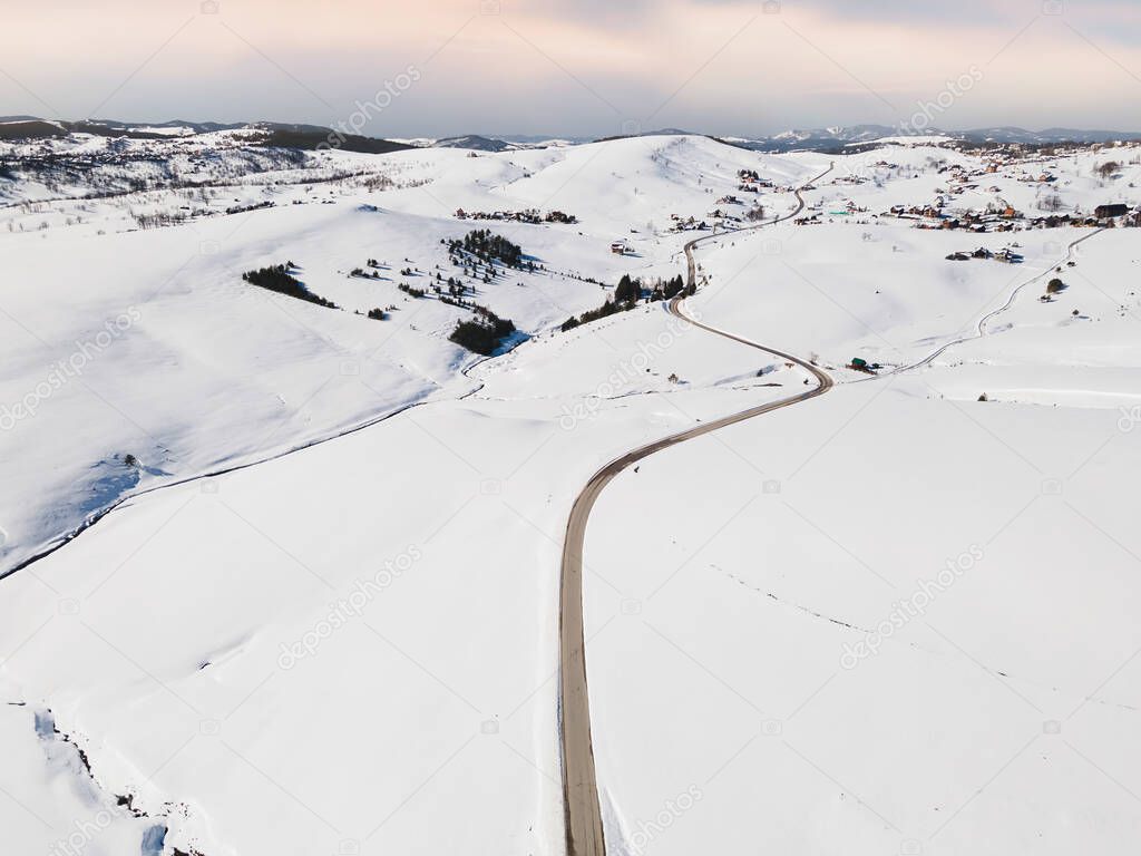 Winter Road. Aerial view of snowy landscape. Winding asphalt road  in the mountains. Zlatibor, mountain resort, Serbia, Europe