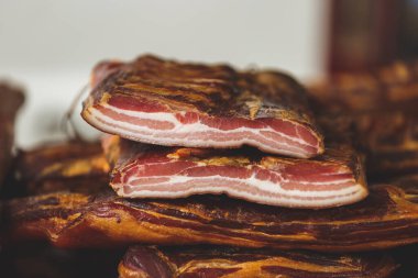 Et pazarındaki dilimlenmemiş lezzetli pastırma standı, seçici bir odak noktası.