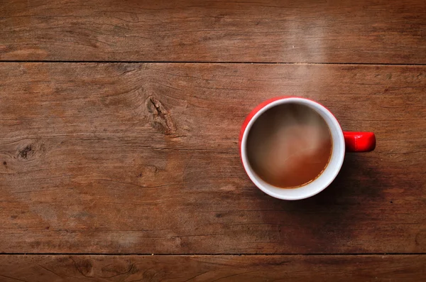 Café de taza roja sobre fondo de madera vieja — Foto de Stock