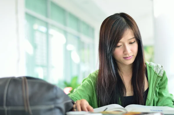 Beautiful asian girl is reading and smile — Stock Photo, Image