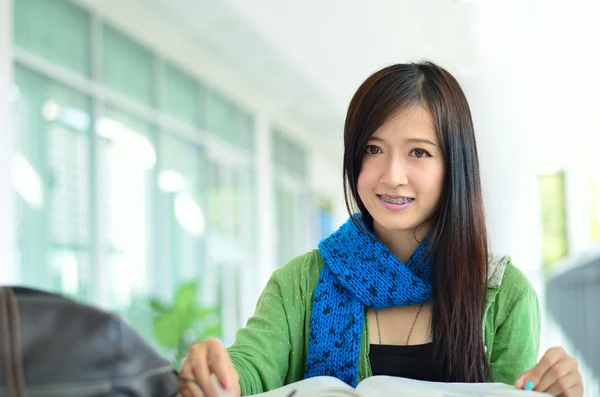 Beautiful asian girl is reading and smile — Stock Photo, Image