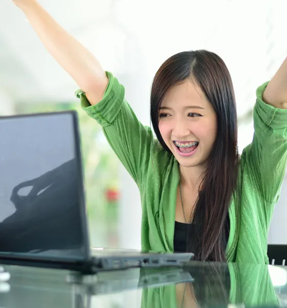 Beautiful young student have good news on the computer screen