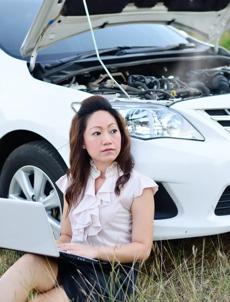 Zakelijke vrouw en auto verdeling op zoek naar mechanic Stockfoto